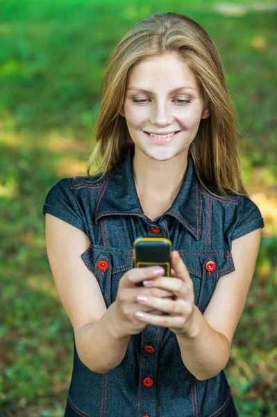 Krásná mladá žena s mobilním telefonem — Stock fotografie