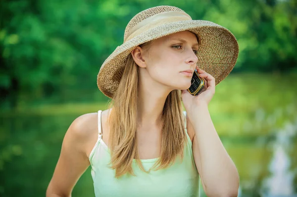 Meisje in stro hoed met telefoon — Stockfoto