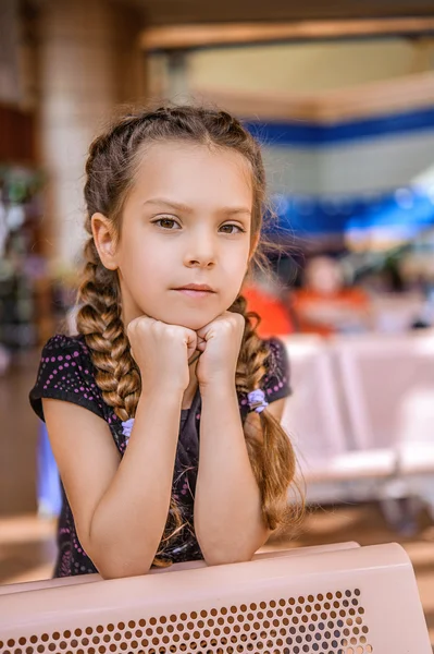 Little girl sitting at table — Stock Photo, Image