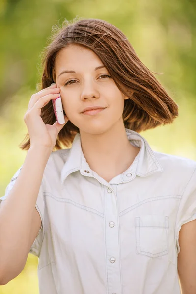 Portrait of young woman speaking on mobile — Stock Photo, Image