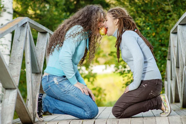 Hermosas chicas jóvenes tomando mordida de una manzana — Foto de Stock