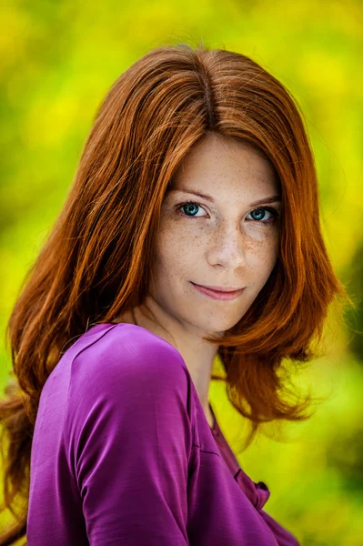 Jeune femme aux cheveux roux en chemisier violet — Photo