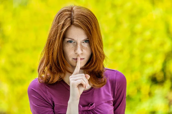 Jovem mulher em coloca seu dedo indicador para os lábios — Fotografia de Stock