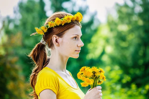 Red-haired woman with wreath and bouquet of dandelions — Stock Photo, Image