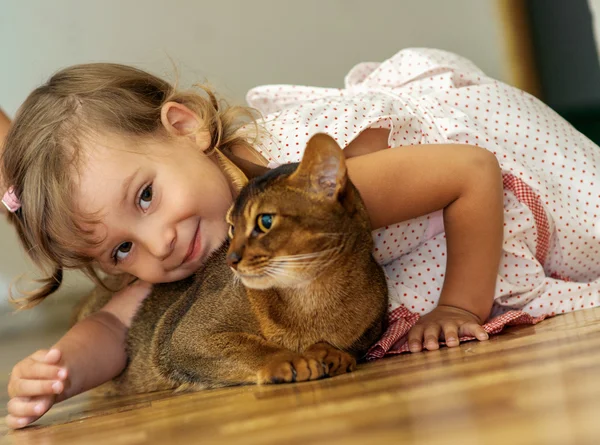 Liten flicka leker med katt — Stockfoto
