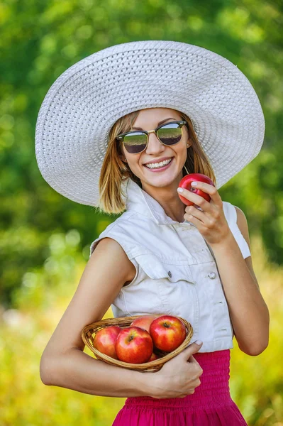 Kvinna solglasögon hatt äpplen — Stockfoto