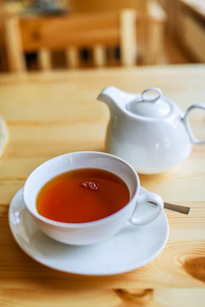 Schwarzer Tee in einer Tasse und weißen Teekanne — Stockfoto