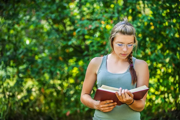 Jovem mulher lê livro — Fotografia de Stock