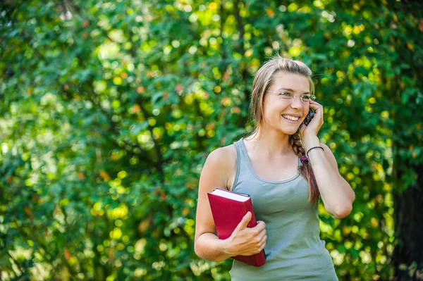 Ung kvinna talar via telefon — Stockfoto