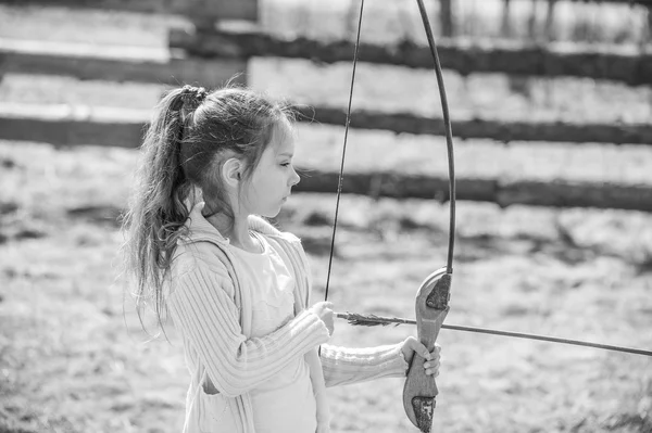 Liten flicka skjuter båge — Stockfoto