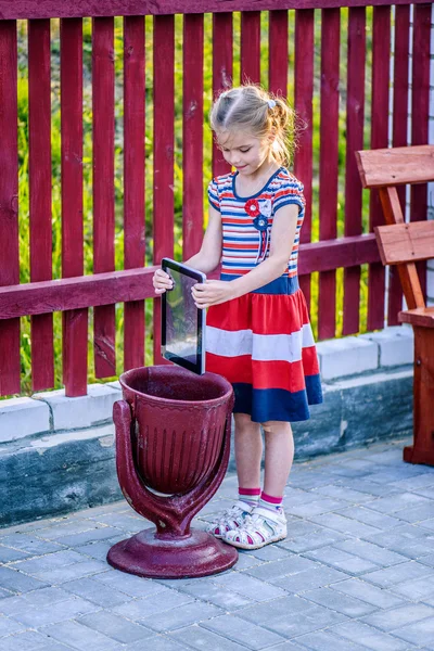 Flicka kastar en tablet-Pc i papperskorgen — Stockfoto