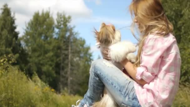 Молодая женщина держит собаку за руки — стоковое видео