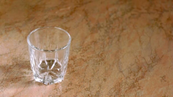 Маленькая стеклянная чашка на столе — стоковое видео