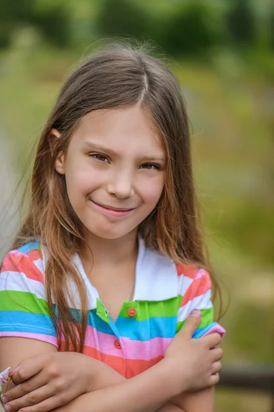 Маленькая девочка улыбается на зеленом фоне — стоковое фото