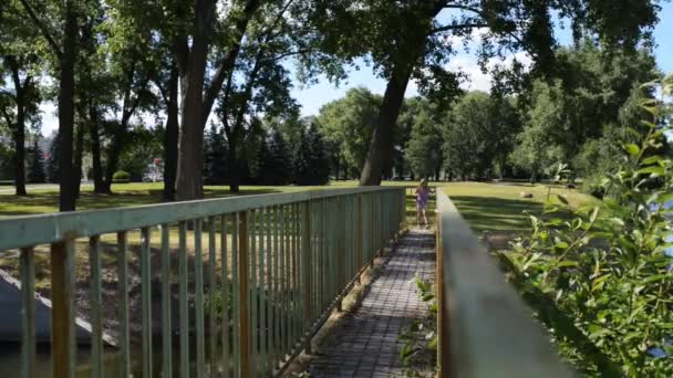 Petite fille va sur le pont métallique 