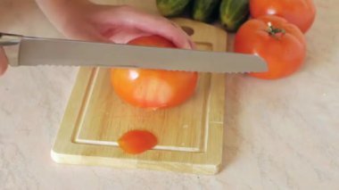 woman with knife cut tomatoes