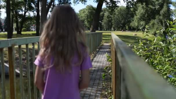 Klein meisje gaat op metalen brug — Stockvideo