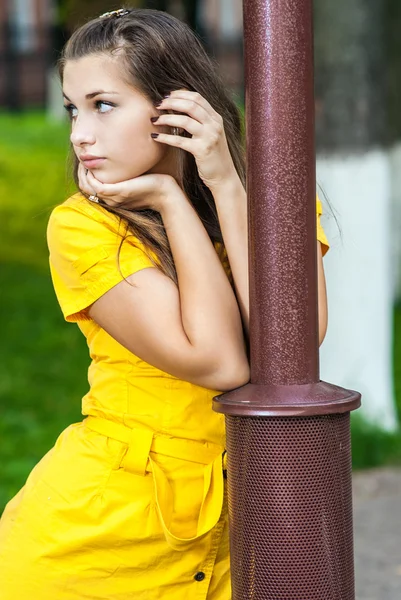 Chica en amarillo en el poste de luz —  Fotos de Stock