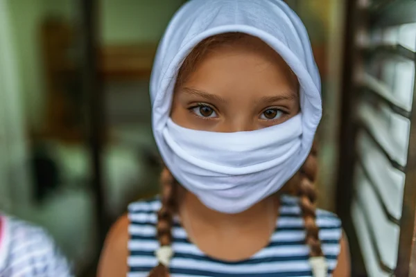 Niña pequeña con máscara blanca — Foto de Stock