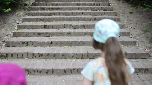 Two sisters go up stone stairs — Stock Video