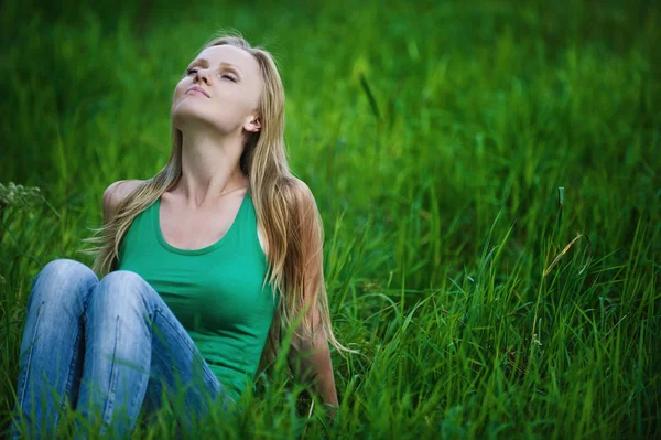 Retrato mujer joven se sienta en la hierba verde — Foto de Stock