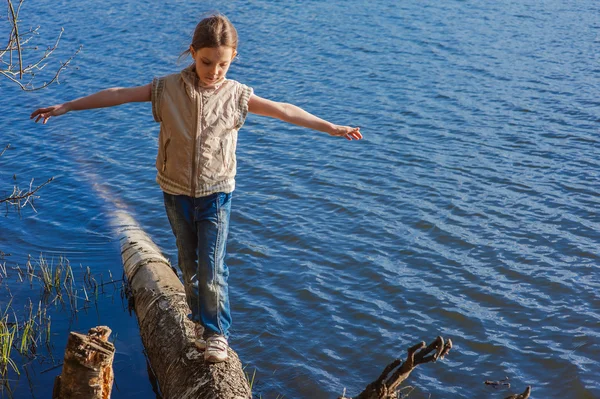 Kleines Mädchen läuft auf Baumstamm — Stockfoto