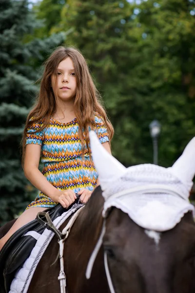 Little girl riding festive horse — Stock Photo, Image