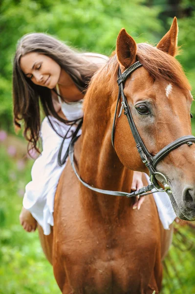 Giovane donna bruna cavalca un cavallo — Foto Stock