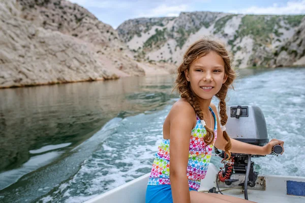 Vidám kislány vezet egy motoros csónak — Stock Fotó