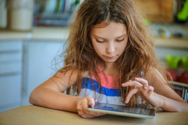 Tablet bilgisayarda çalışan küçük kız