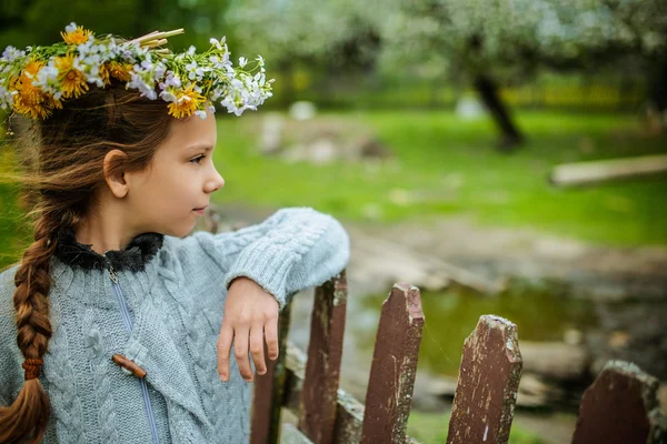 Kleines Mädchen mit Blumenkranz auf dem Kopf — Stockfoto