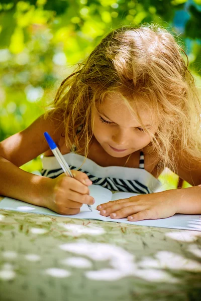 Niña escribe pluma en cuaderno — Foto de Stock