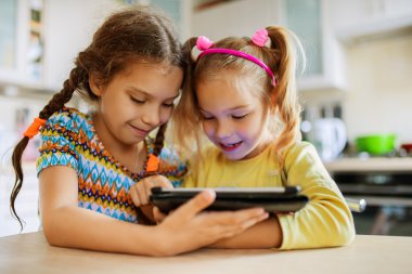 İki küçük kız kardeşi bir Tablet PC'de oynamak