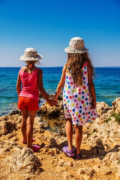 Duas irmãzinhas em praias rochosas de mar — Fotografia de Stock