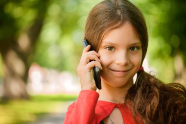 Little smiling girl talking on cell phone