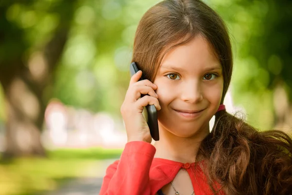 Little smiling girl talking on cell phone — Stock Photo, Image