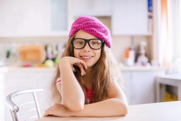 Petite fille s'assoit à une table dans la cuisine — Photo