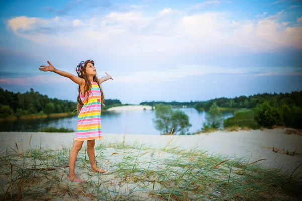 Little beautiful girl standing on sand — Stockfoto