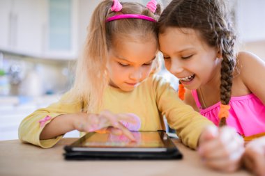 İki küçük kız kardeşi bir Tablet PC'de oynamak