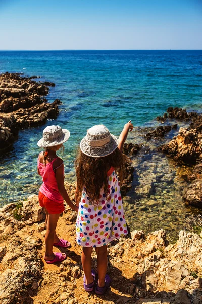 Duas irmãzinhas em praias rochosas de mar — Fotografia de Stock