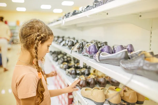 Little girl chooses shoes — Stock Photo, Image