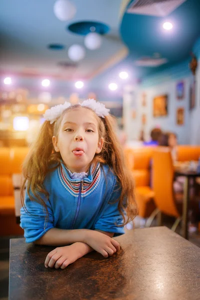 Маленькая красивая девочка показывает язык — стоковое фото