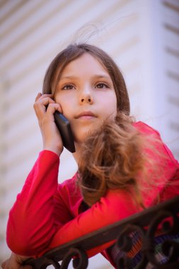 Little beautiful girl talking on cell phone.