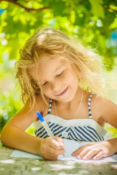 Kleines Mädchen schreibt Stift in Notizbuch — Stockfoto