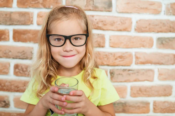 Smiling little girl drinks water — Stok fotoğraf