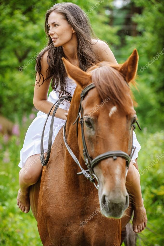 Young brunette woman rides a horse — Stock Photo © BestPhotoStudio