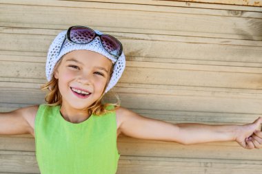 şapka ve güneş gözlüğü ile gülümseyen küçük kız
