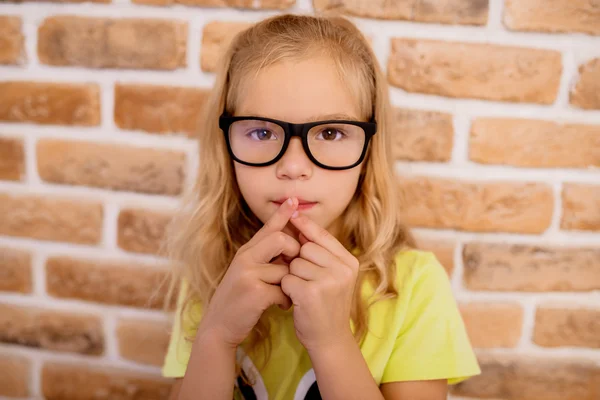 Petite fille intelligente dans des lunettes avec des montures noires — Photo