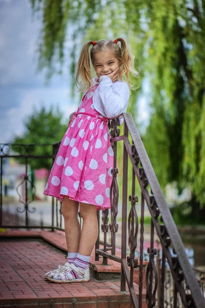 Glimlachend meisje in roze jurk — Stockfoto