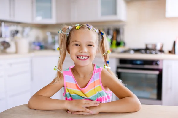 Little girl sitting at table — Stock Photo, Image